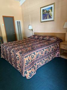 a large bed in a hotel room with a bedspread at Fireside Inn in King City +6 photos