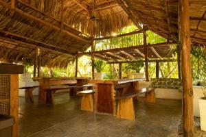 a pavilion with wooden tables and benches in it at Hotel PlayaScondida Baru in Barú +32 photos