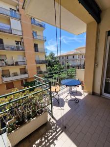 a balcony with a blue table and chairs on a building at Gemstone Colors Flat in Chiavari