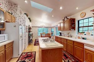 a kitchen with wooden cabinets and a white refrigerator at Lakeside Livin' in Pinetop-Lakeside