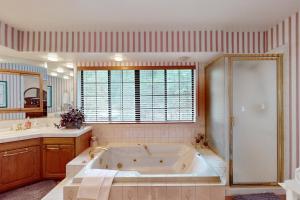 a large bath tub in a bathroom with a window at Lakeside Livin' in Pinetop-Lakeside +17 photos