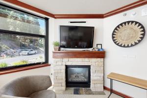 ein Wohnzimmer mit einem Kamin und einem Flachbild-TV in der Unterkunft Everline Resort #241 & #243 in Olympic Valley