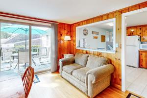 a living room with a couch and a kitchen with a balcony at Yarmouth Bliss in Yarmouth