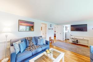 a living room with a blue couch and a table at Yarmouth Bliss in Yarmouth