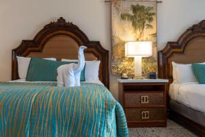 a hotel room with two beds and a towel animal on the bed at Pacific Terrace Hotel in San Diego