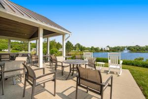 a patio with tables and chairs and a lake at Millville by the Sea --- 35015 Sunfish Ln in Millville