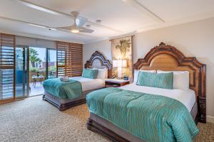 a hotel room with two beds and a balcony at Pacific Terrace Hotel in San Diego