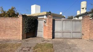 a house with a garage with a brick wall at 760 A Apartamentos in Alta Gracia +2 photos
