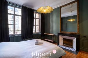 Le Lafayette Coeur de ville 6 personnes في نانسي: غرفة نوم بسرير ومرآة ومدفأة