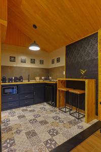 a kitchen with a table and a tile floor at Requinte dos Pinhais Chalé in Santo Antônio do Pinhal +12 photos