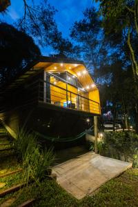 a house with lights on the side of it at Requinte dos Pinhais Chalé in Santo Antônio do Pinhal