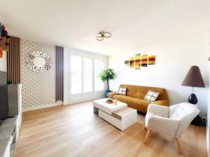 a living room with a couch and a table at NOZA Appartement 65m2, 2 chambres - RDC, Parking gratuit, Nantes agglo Rezé in Rezé