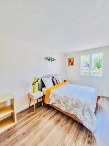 a bedroom with a large bed and a window at NOZA Appartement 65m2, 2 chambres - RDC, Parking gratuit, Nantes agglo Rezé in Rezé +13 photos