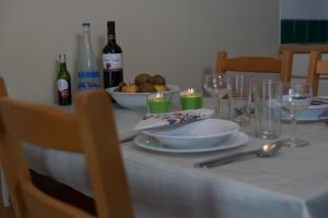 - une table avec des assiettes, des verres et des bouteilles de vin dans l'établissement Apparthotel De Wielingen, à Westende