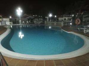 a large swimming pool at night with lights at Appartamento Puerta del Sol in Caleta De Fuste