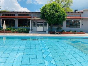 a swimming pool in front of a house at HOTEL EX HACIENDA EL MOLINO in Ciudad Hidalgo