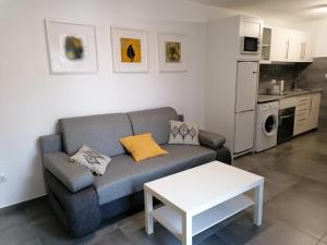 a living room with a couch and a table at Appartamento Puerta del Sol in Caleta De Fuste
