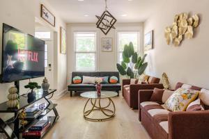 a living room with a couch and a tv at Renovated 5BR DC Home Naer Capitol Area Free Parking in Washington