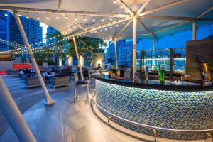 a rooftop bar with a view of the city at night at Park Plaza Bangkok Soi 18 in Bangkok