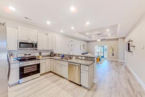 a large kitchen with white cabinets and appliances at Cocora on Church Street - B in Myrtle Beach