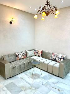 a living room with a couch and a chandelier at Luxueux Appartement Parc Champs de Cours avec Wifi Fibre 200 Mo in Fès