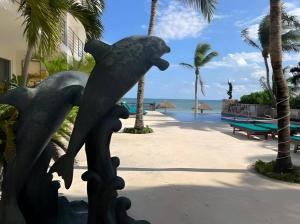 Una estatua de un pájaro en un poste junto a la playa. en Palma Real By Andiani Travel, en Puerto Morelos