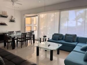 Una sala de estar con un sofá, una mesa y sillas. en Palma Real By Andiani Travel, en Puerto Morelos