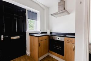 a kitchen with black appliances and a black refrigerator at Withernsea Studio Apt & Sofa bed in Withernsea