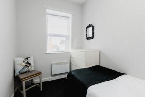 ウィズンシーにあるWithernsea Studio Apt & Sofa bedのベッドと窓のある白い寝室