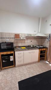 a kitchen with a sink and a stove at 760 B Apartamentos in Alta Gracia +3 photos