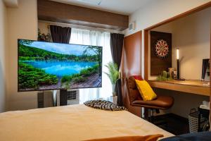 una camera da letto con una grande TV a schermo piatto a parete di South 1014 a Sapporo
