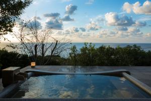 a swimming pool with a view of the ocean at 間人温泉 炭平 in Kyotango
