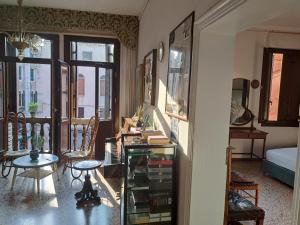 a living room with a table and a room with a bed at C&agrave; Widmann in Venice