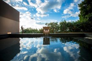 a swimming pool with a blue sky and clouds at 間人温泉 炭平 in Kyotango