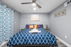 a bedroom with a blue bed with a ceiling fan at Central Heights 2BR Oasis with Pool & Free Park in Houston +16 photos