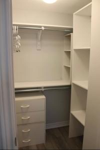 a walk in closet with white cabinets and shelves at Oakville Townhouse Amazing Rooftop in Oakville