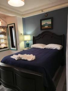 a bedroom with a bed with purple sheets and pillows at Apartamento Pana Casa Santa Elena Céntrico in Panajachel