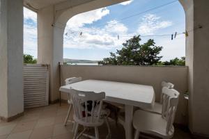 a white table and chairs on a balcony with a window at Apartment Vidalici 6519f in Kustići