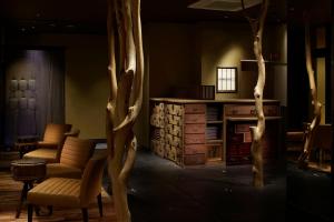 a room with chairs and a table and trees at 間人温泉 炭平 in Kyotango
