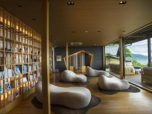 a library with white furniture and bookshelves at 間人温泉 炭平 in Kyotango
