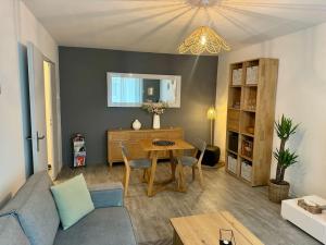 ein Wohnzimmer mit einem blauen Sofa und einem Tisch in der Unterkunft Appartement 4 personnes idéal Disney et Paris in Torcy