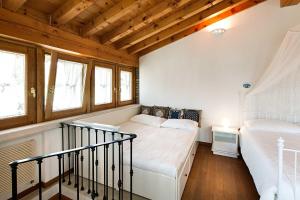 a bedroom with two beds and two windows at Antico Cascinale Lombardo in Lonato del Garda