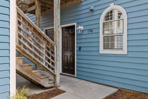 ein blaues Haus mit Holztür und Treppe in der Unterkunft UNCW-Wrightsville Beach-Private Apartment in Wilmington