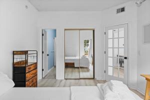 ein weißes Zimmer mit einem Bett und einem Spiegel in der Unterkunft UNCW-Wrightsville Beach-Private Apartment in Wilmington + 27 Fotos