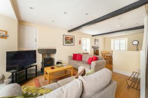 Una sala de estar con un sofá y un televisor. en The Nook, en Ambleside