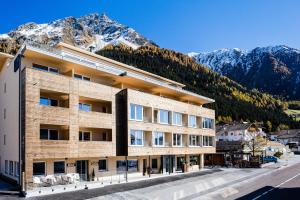 a building with mountains in the background at Aktiv Hotel Edelweiss in Resia