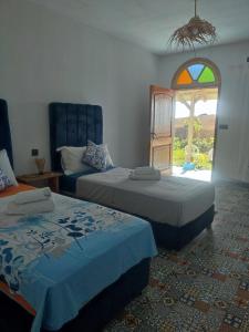 a room with two beds and a window with a window at Darna 4 in Demina +13 photos