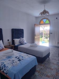 a bedroom with two beds and a stained glass window at Darna 4 in Demina +13 photos