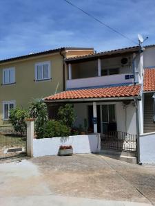 a house with a white fence in front of it at Apartments with parking space Cizici, Krk - 15415 in Malinska