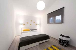Un dormitorio con una cama en una habitación blanca. en Holiday home in Rijeka 49910, en Rijeka 28 fotos más